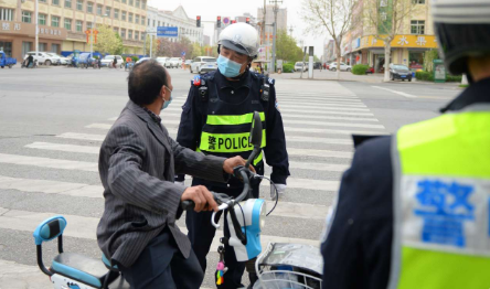 4月11日，河北白沟新城公安分局交警大队执勤民警，劝导市民骑行要配戴头盔。冯云 摄