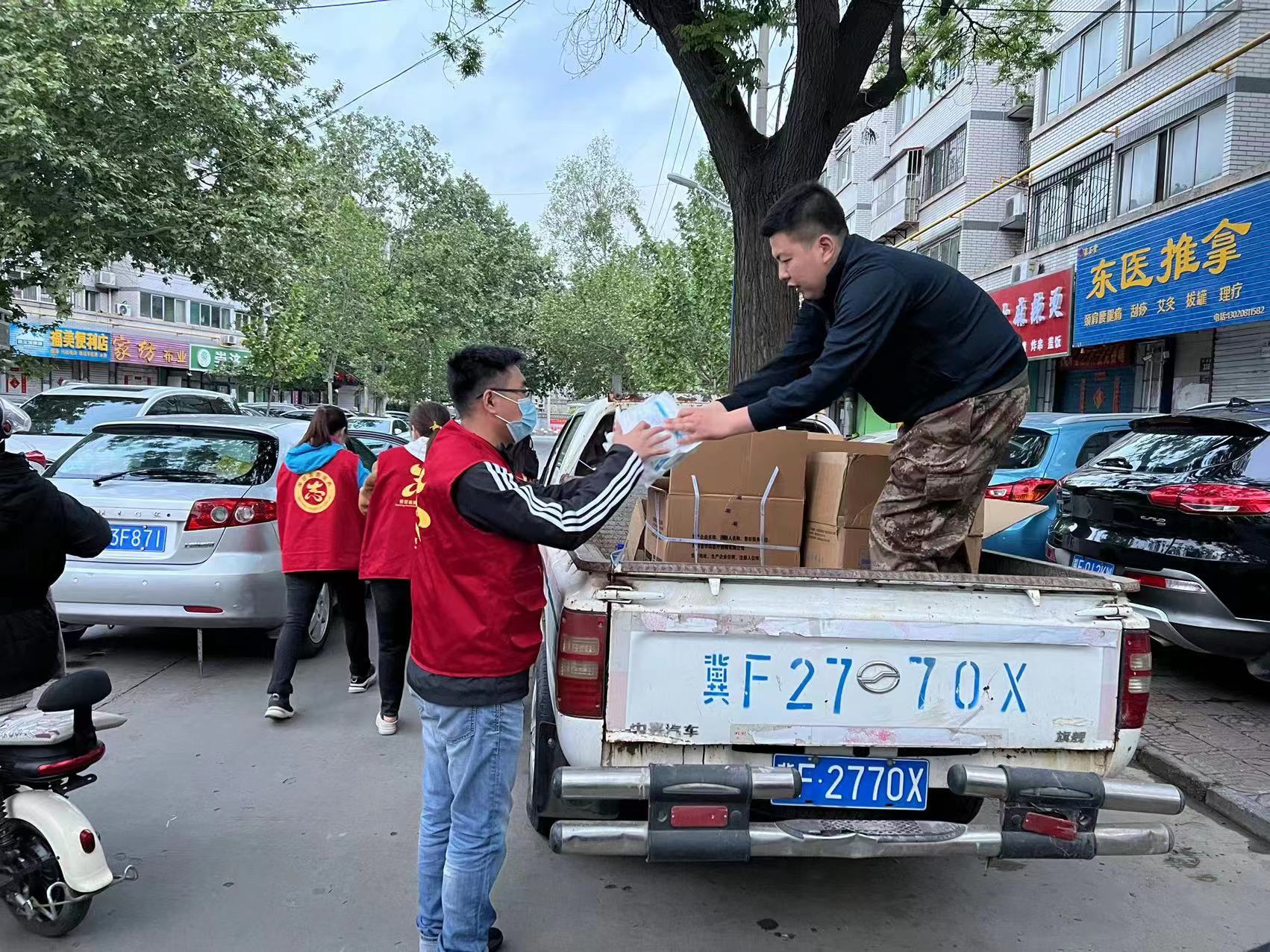 吴冠辰正在分发蔬菜包。
