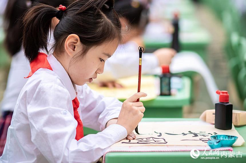 呼和浩特市玉泉区恒昌店巷小学学生在参加汉字书写大赛软笔项目的比赛。丁根厚摄