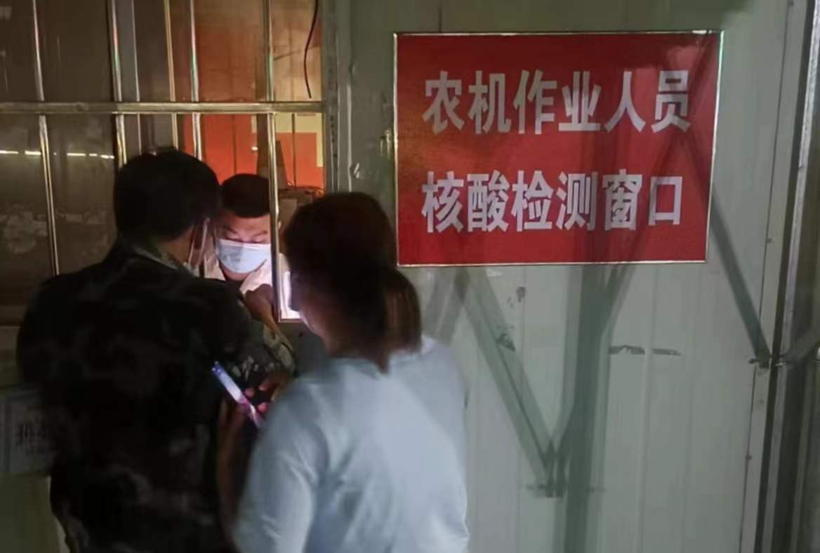 高速口的跨区作业农机接待服务站24小时不间断接待跨区农机及人员。图为深夜为农机手做核酸及抗原检测。徐水区农业农村局供图