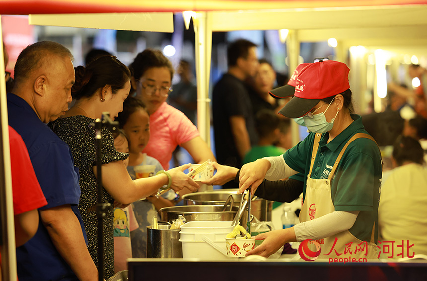 石家庄赛场外“足球市集”，络绎不绝的观众排队品尝石家庄特色美食。人民网记者 李兆民摄